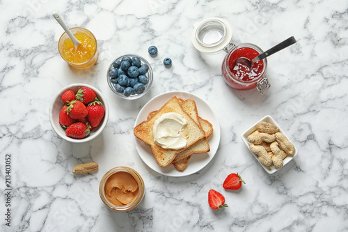 Flat lay composition with toast bread and toppings on marble background