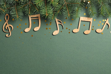 Flat lay composition with fir tree branches and notes on color background. Christmas music concept