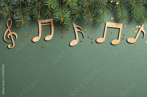 Flat lay composition with fir tree branches and notes on color background. Christmas music concept