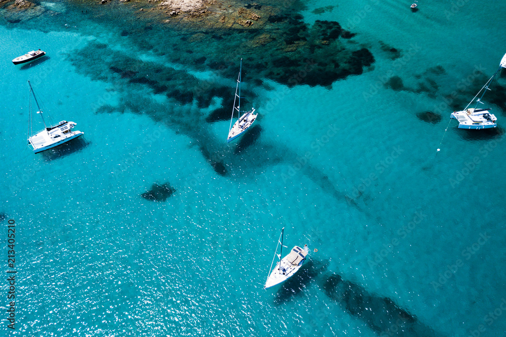 Naklejka premium Aerial view of some yachts on an emerald and transparent Mediterranean sea. Gulf of the Great Pevero, Emerard coast, Sardinia, Italy.