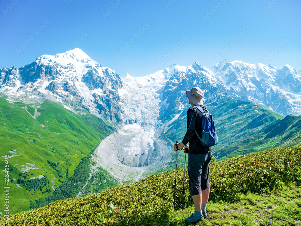 Obraz premium Tourist with a backpack in front of Glacier in Caucasus mountains. Svaneti region, Georgia