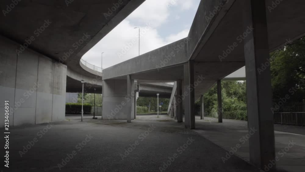 Moving shot of urban overpass with clouds in the sky, lampposts and green trees on the side. Moving shot of urban overpass with clouds in the sky, lampposts and green trees on the side.