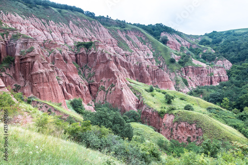 Red Ravine (Rapa Rosie) geological reserve in The Carpathian Mountains similar to Cappadocia. Rock formations in unusual shapes formed of erosion by rainwater. Transilvanya, Sebes, Romania.  photo