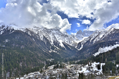 Falcade panoramic view. Winter city in the mountains. Italy, Alps, Dolomites, Falcade. Falcade winter landscape,Dolomites; winter white view of touristic village in Dolomites,shot under deep blue sky.