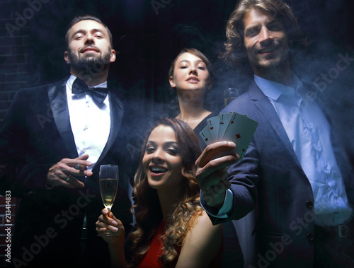 Four people toasting with champagne at roulette in casino