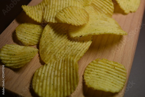 Fototapeta Potatoes fried wavy, embossed, potato chips with sour cream and greens, facies o