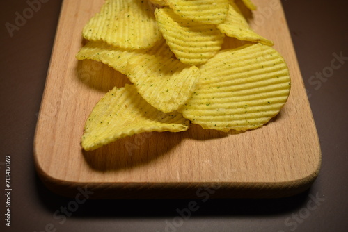 Fotografie Potatoes fried wavy, embossed, potato chips with sour cream and greens, facies o