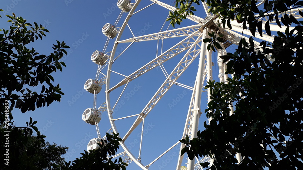 Modern ferris wheel at a fair in summer, with day blue sky background. Modern ferris wheel at a fair in summer, with day blue sky background.