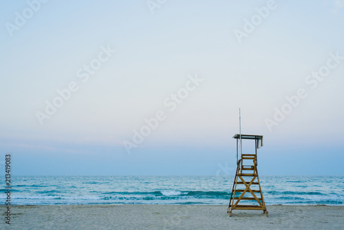 Lifeguard watchtower on the beach at sunset.