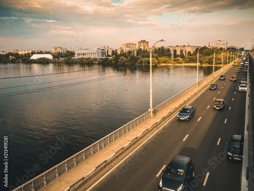 Cars on asphalt road on bridge over river  city traffic and transportation concept