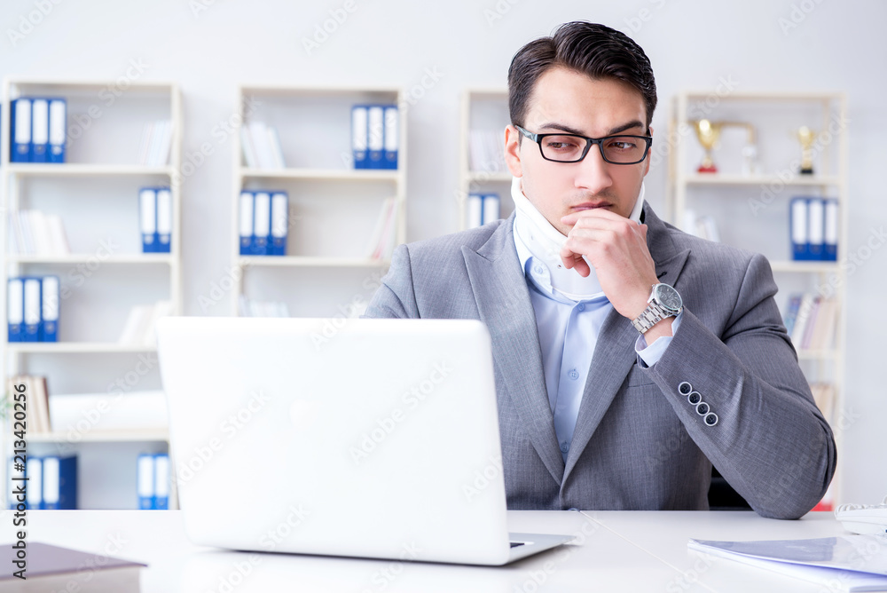 Businessman with neck injury working in the office Businessman with neck injury working in the office