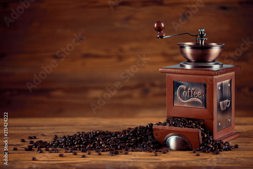 Kaffee Mühle mit Kaffeebohnen und altem rustikalen Holz Tisch Hintergrund photo