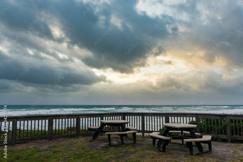 two picnic tables overlooking the ocean