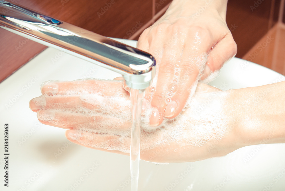 Fototapeta premium Washing of hands with soap under running water in bathroom, hygiene concept