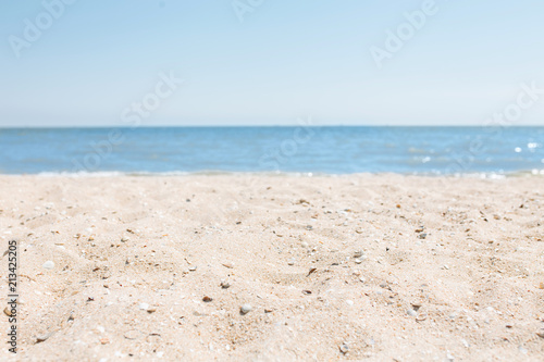 Sand close-up  against the background of a blurred blue sea or ocean  an empty beach  Sunny day