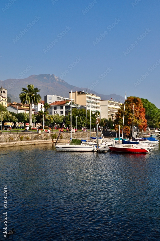 Fototapeta premium Port w mieście Locarno nad jeziorem Maggiore, jezioro w górach Ticino / Cardada w tle w południowej Szwajcarii