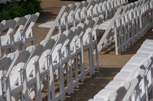 Fototapeta Naklejka Na Ścianę i Meble -  Rows of white wooden folding chairs set up for an outdoor event
