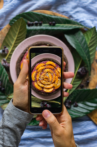 Smartphone food photography of vegetarian lunch or dinner. Woman hands taking phone photo of food in trendy style for social media or blogging.