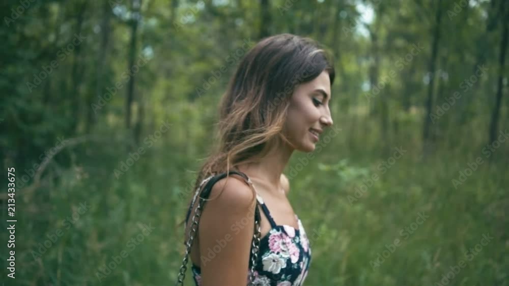 Cheerful young woman in forest walking on road and laughing, slow motion, shallow depth of field Cheerful young woman in forest walking on road and laughing, slow motion, shallow depth of field