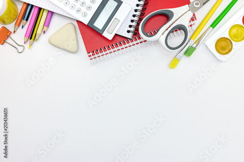 various school supplies and tools on white desk background with copy space, flat view