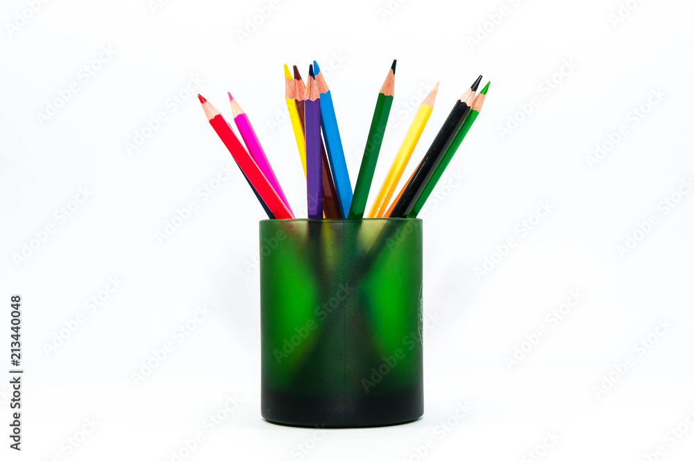 Color pencils in a green cup close up shot isolated on white background.