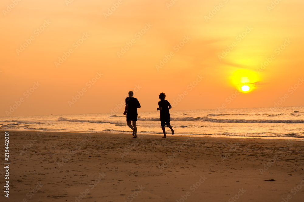 people running on the beach at the morning