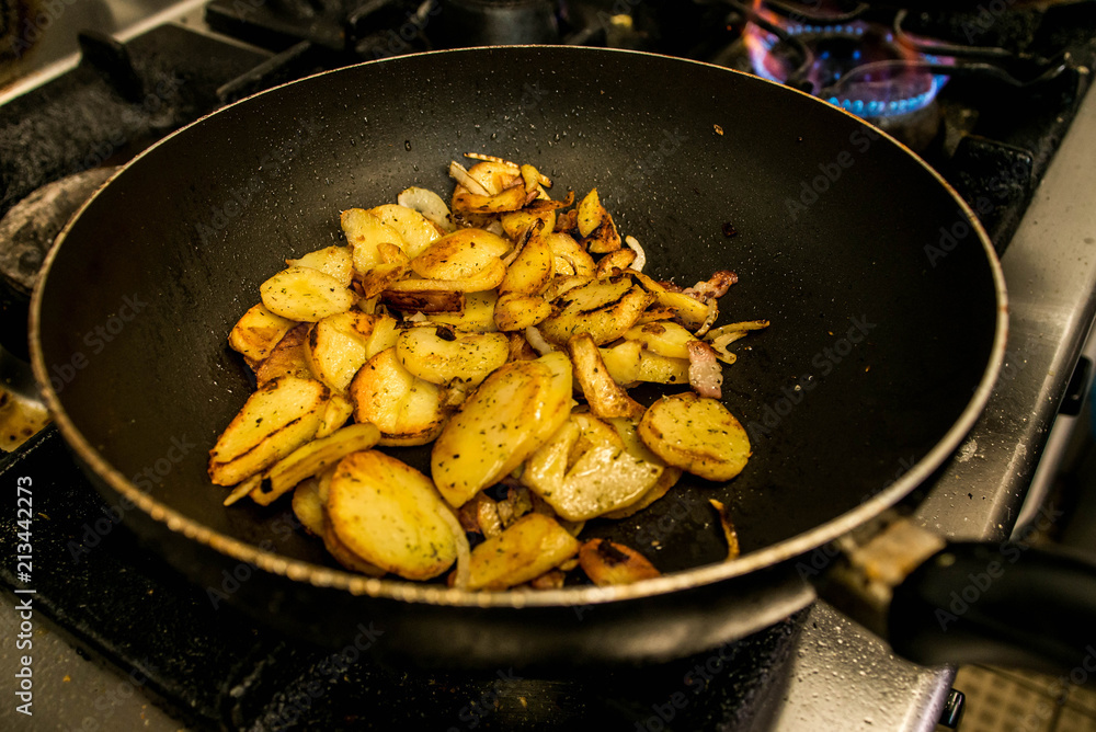 potatoes fried in oil in a frying pan with herbs for autrian food potatoes fried in oil in a frying pan with herbs for autrian food