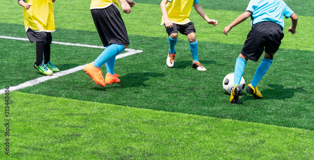 Asian boy playing football at the stadium, sports, outdoor activities Asian boy playing football at the stadium, sports, outdoor activities