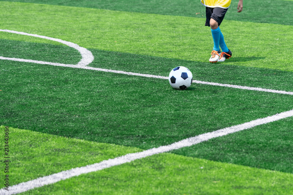 Asian boy playing football at the stadium, sports, outdoor activities Asian boy playing football at the stadium, sports, outdoor activities