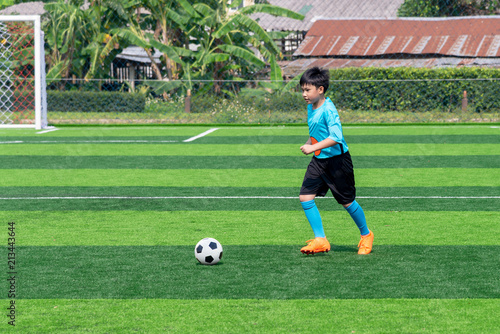 Asian boy playing football at the stadium, sports, outdoor activities