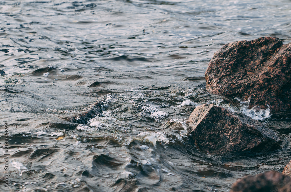 Obraz premium Stone shore and waves of the Gulf of Finland. North nature. Close-up view.
