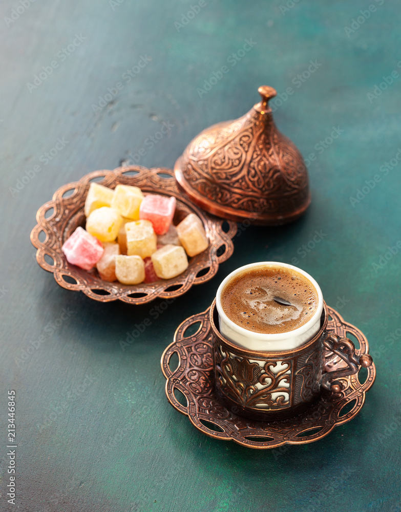 Traditional turkish coffee and turkish delight on dark green wooden background.