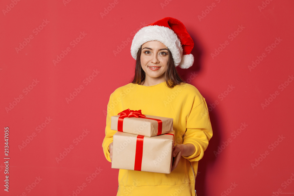 Young woman with Christmas gifts on color background Young woman with Christmas gifts on color background