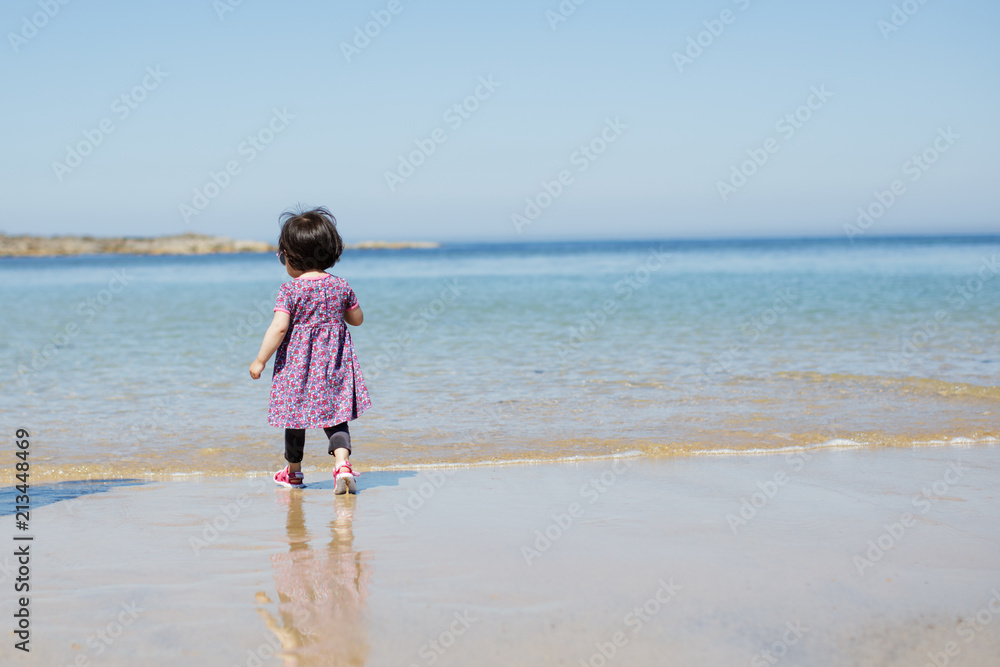 baby girl wearing sunglasses running on the summer beach baby girl wearing sunglasses running on the summer beach