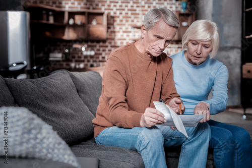 It is here. Concentrated woman sitting near her husband while pointing at document