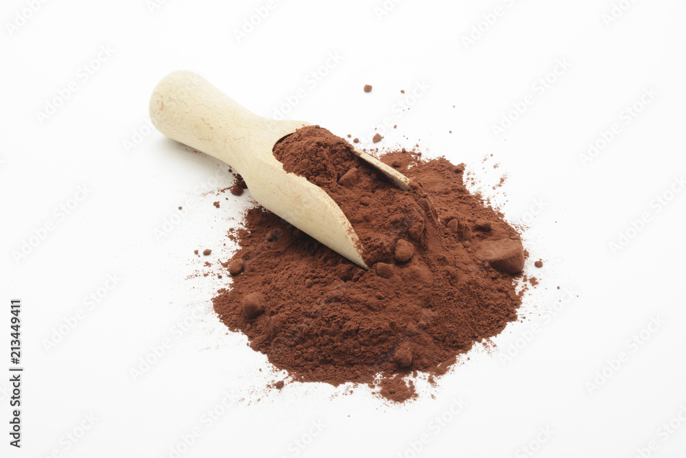 Cacao en polvo y cuchara de madera sobre fondo blanco Cacao en polvo y cuchara de madera sobre fondo blanco