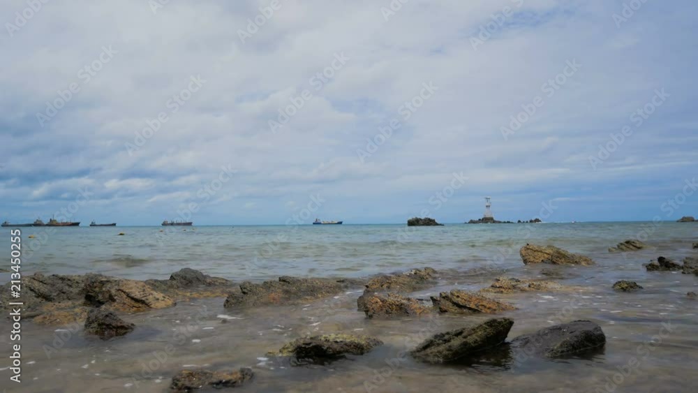 Sea wave with small rock beach with cloudy sky