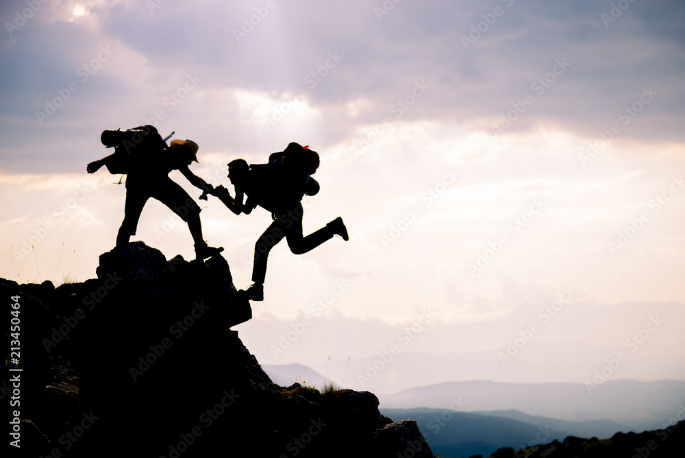 Fototapeta premium adventurous people;Hikers climbing on mountain. Help, risk, support, assistance