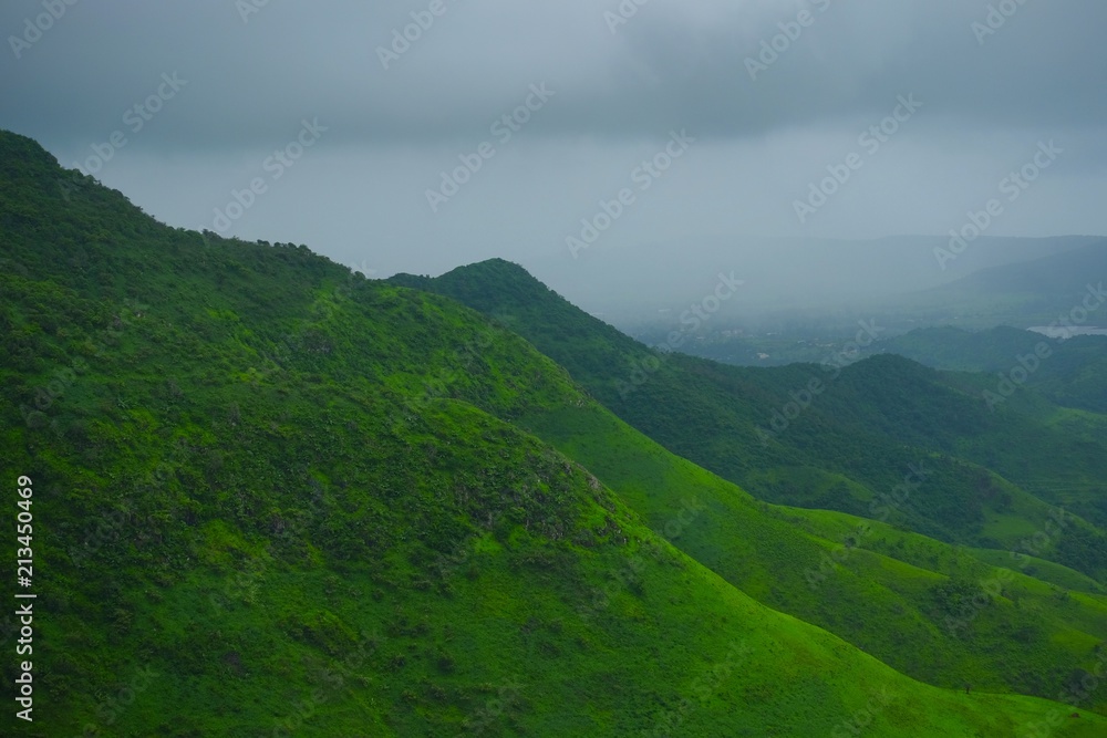 Fototapeta premium Green landscape surrounded by hills, mountains in monsoon season 