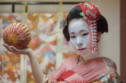 Vászonkép Maiko in kimono holding a temari ball in the hand.