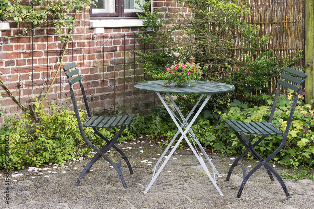 Chairs and table in the garden of an idyllic rural cottage house