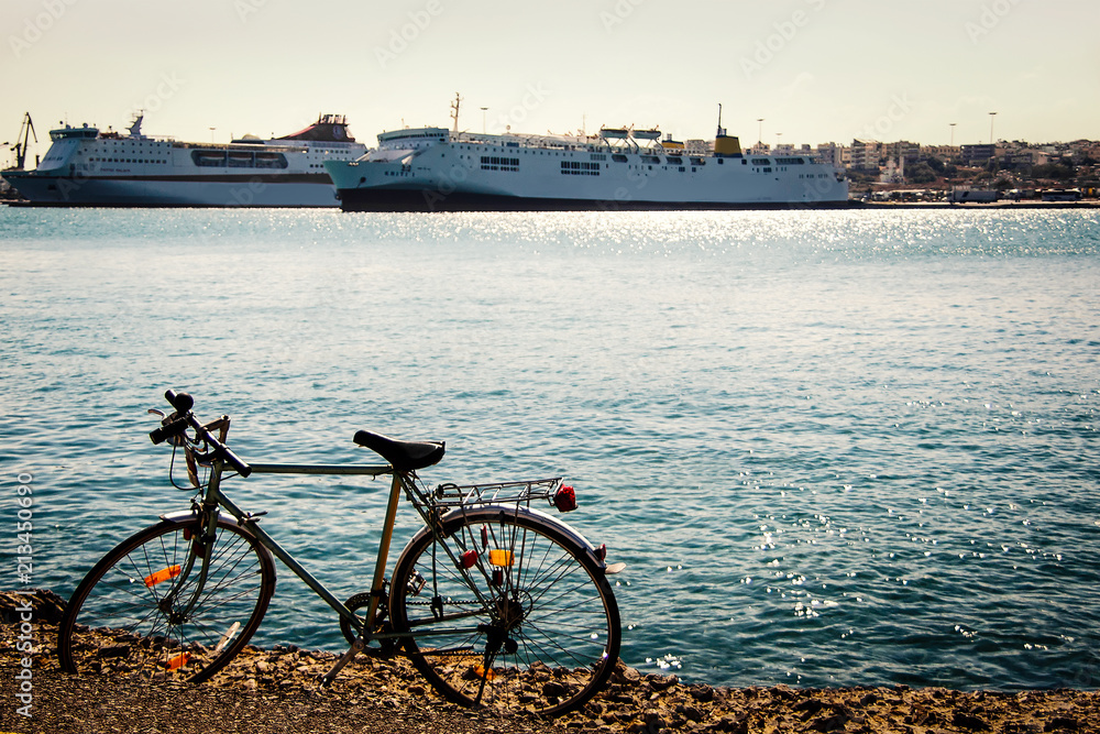 Vintage bycicle parked on the beach against  modern ocean liners