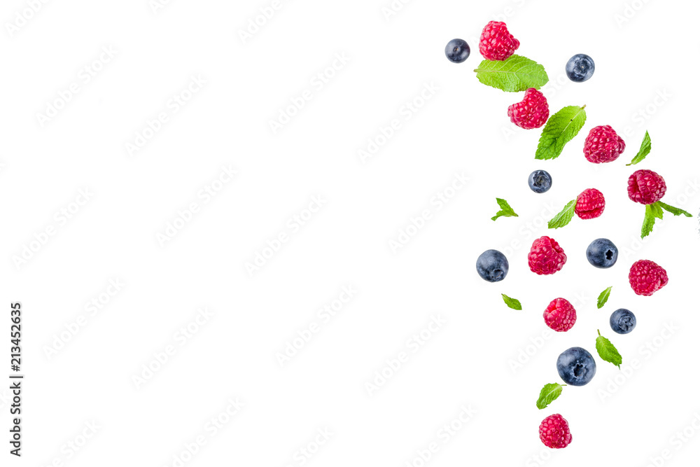 Creative layout, background, with fresh berries, simple pattern on white background. Raspberry, blueberry, mint leaves, slices of lemon.