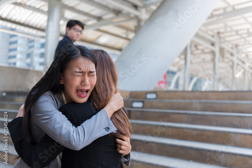 A picture of a beautiful businesswoman comforting a workmate