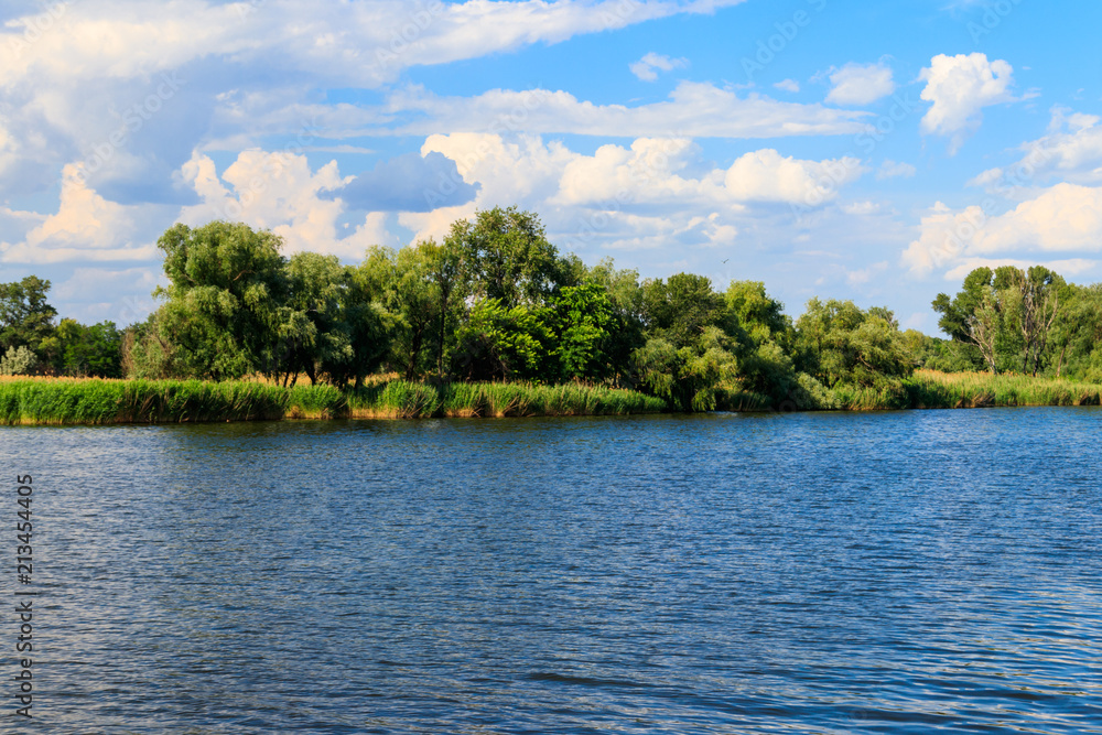 Summer landscape with beautiful lake, green trees and blue sky Summer landscape with beautiful lake, green trees and blue sky