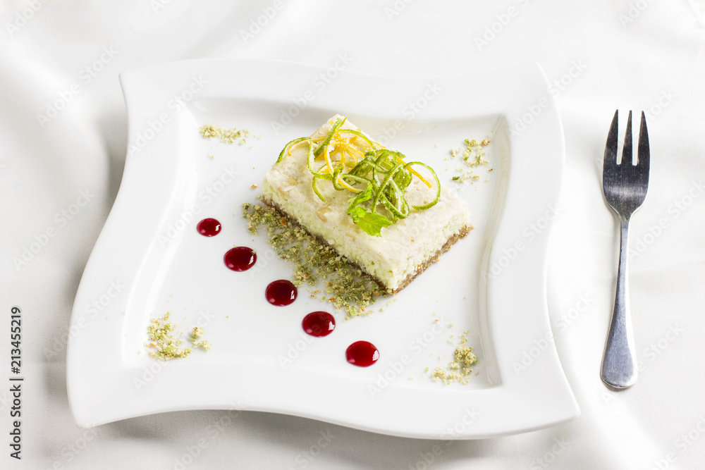 Raw food dessert cake with lemon and lime candied fruits on white plate Raw food dessert cake with lemon and lime candied fruits on white plate