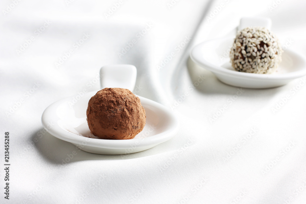Homemade healthy raw candy truffle with sesame and chocolate on white background Homemade healthy raw candy truffle with sesame and chocolate on white background
