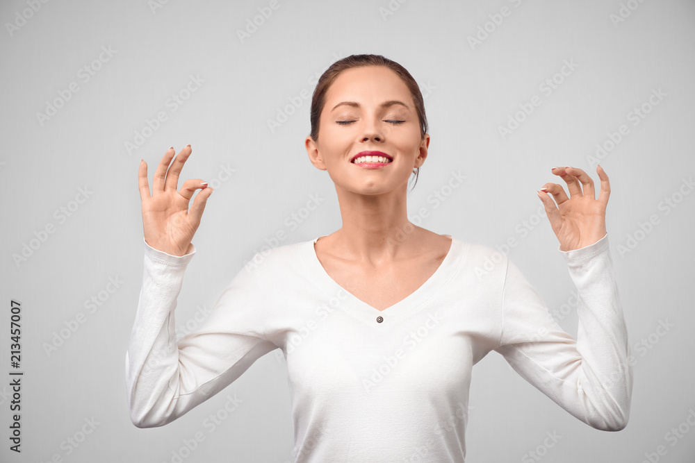 People, peace, body language and meditation concept. Cheerful brunette young female with glad expression, shows ok sign with both hands, dressd in casual white t shirt, demonstrates approval People, peace, body language and meditation concept. Cheerful brunette young female with glad expression, shows ok sign with both hands, dressd in casual white t shirt, demonstrates approval