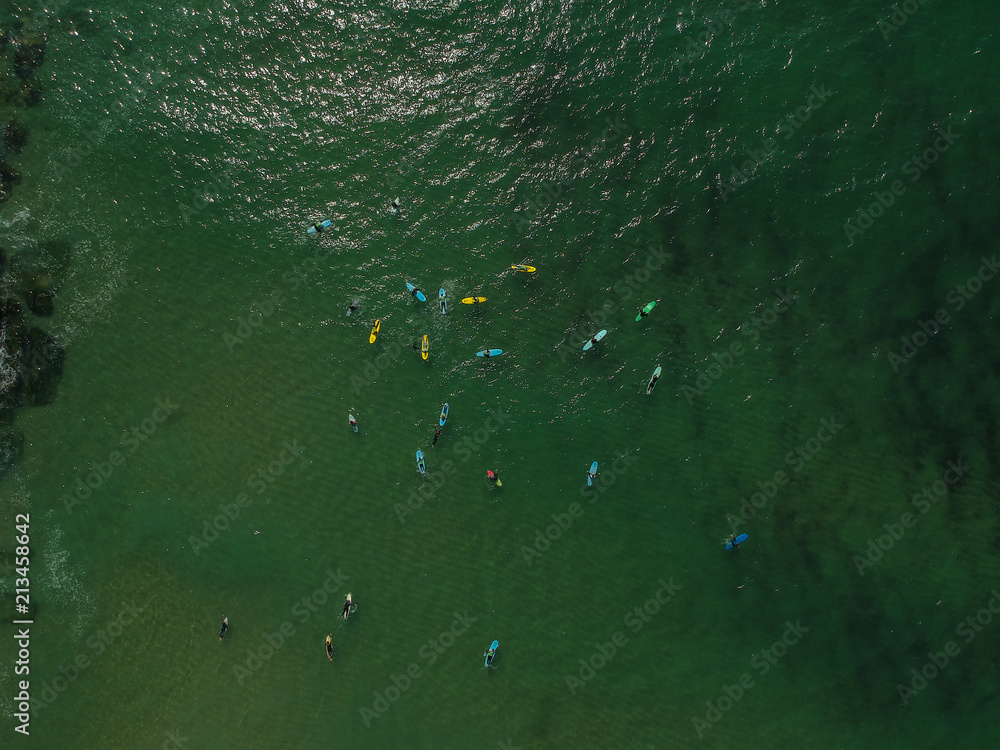 Aerial view of surfers in the ocean on a summer day. Surf Spot on the Portuguese coastline. Drone shot. Aerial view of surfers in the ocean on a summer day. Surf Spot on the Portuguese coastline. Drone shot.