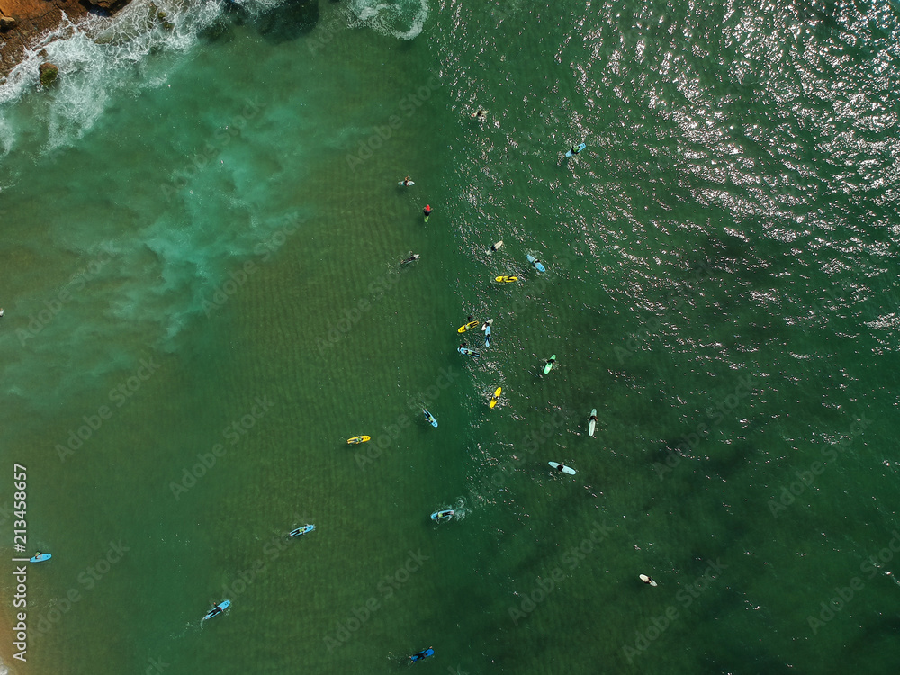 Aerial view of surfers in the ocean on a summer day. Surf Spot on the Portuguese coastline. Drone shot. Aerial view of surfers in the ocean on a summer day. Surf Spot on the Portuguese coastline. Drone shot.